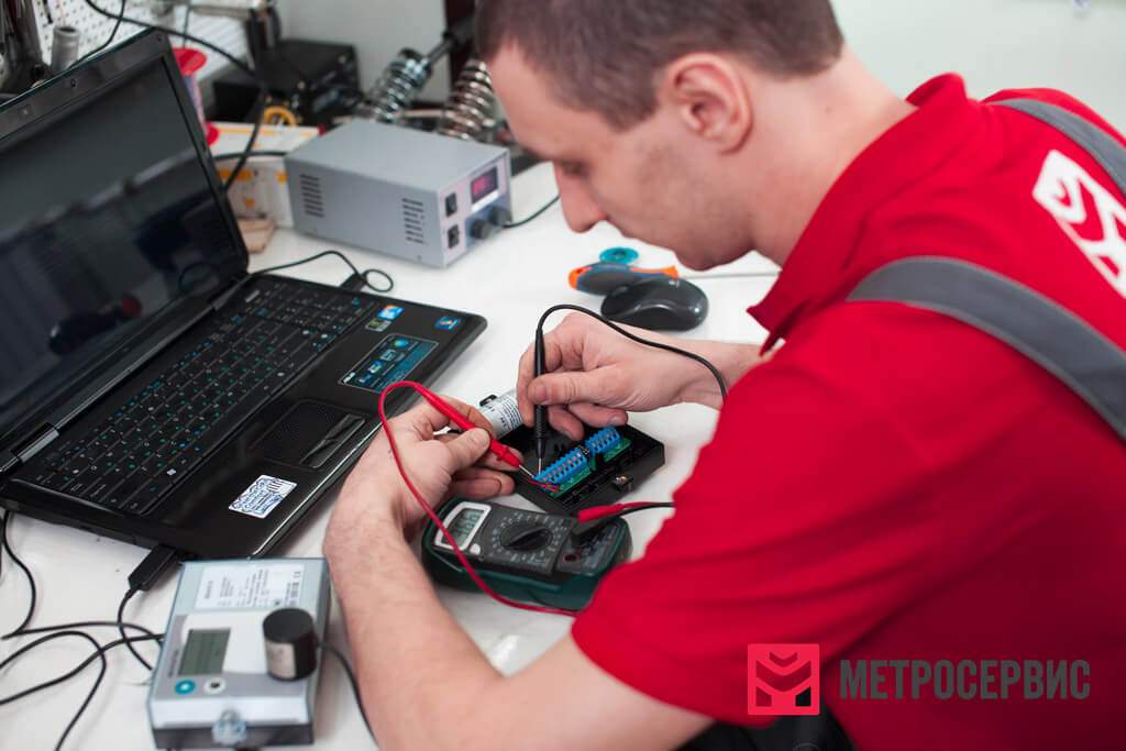 Работник настраивает тепловычислитель